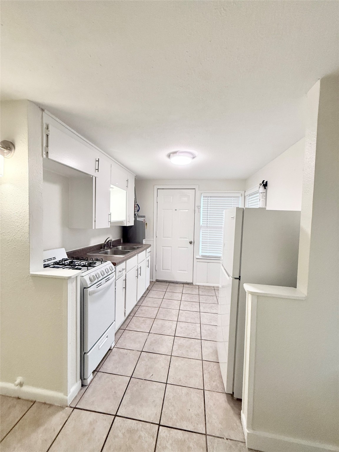 2714 Carrolton Street, Unit BACK Houston, TX 77023 - Photo 7 of 14 a kitchen with granite countertop a refrigerator and a stove top oven