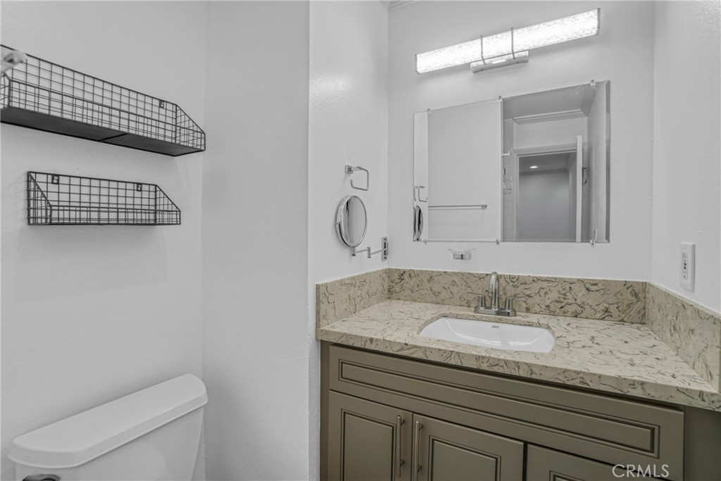 7765 West 91st Street, Unit F1113 Playa del Rey, CA 90293 - Photo 24 of 41 a bathroom with a granite countertop sink and a mirror