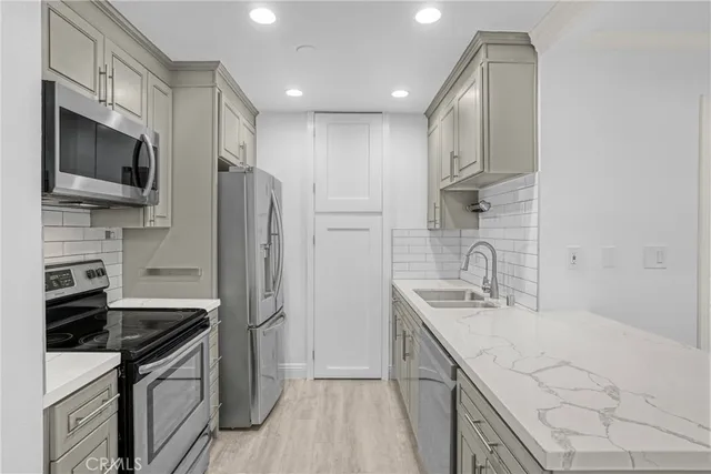 a view of kitchen with granite countertop cabinets and refrigerator