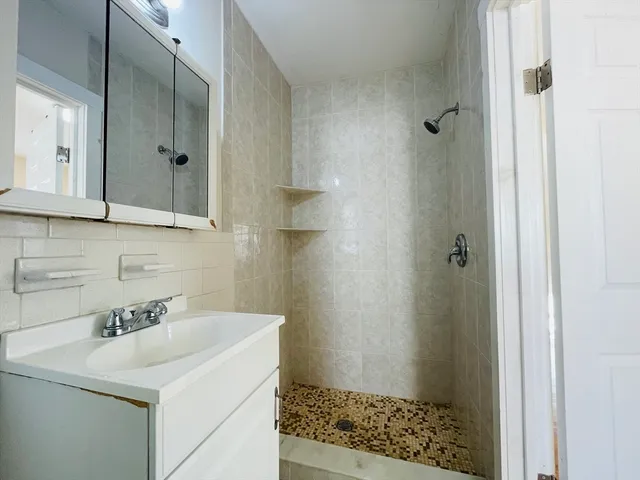 a bathroom with a sink a toilet and shower