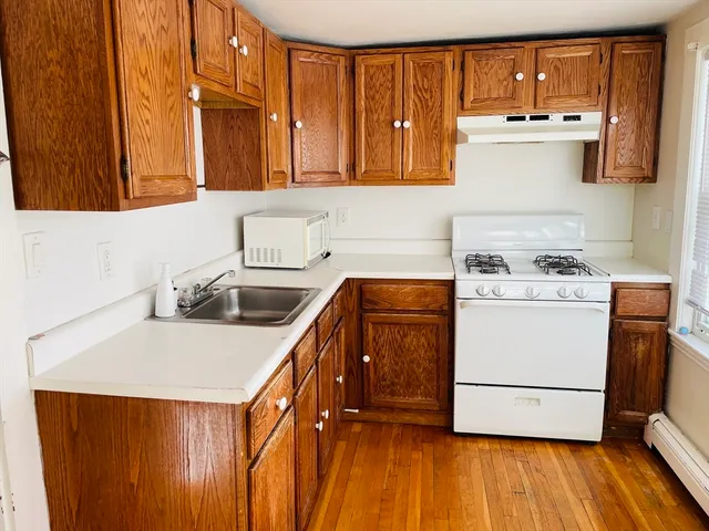 a kitchen with a sink a stove and cabinets