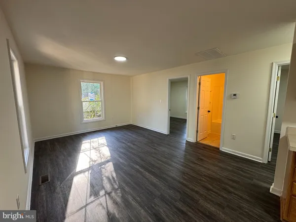 an empty room with wooden floor and a window