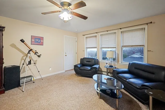 a living room with furniture a ceiling fan and a window