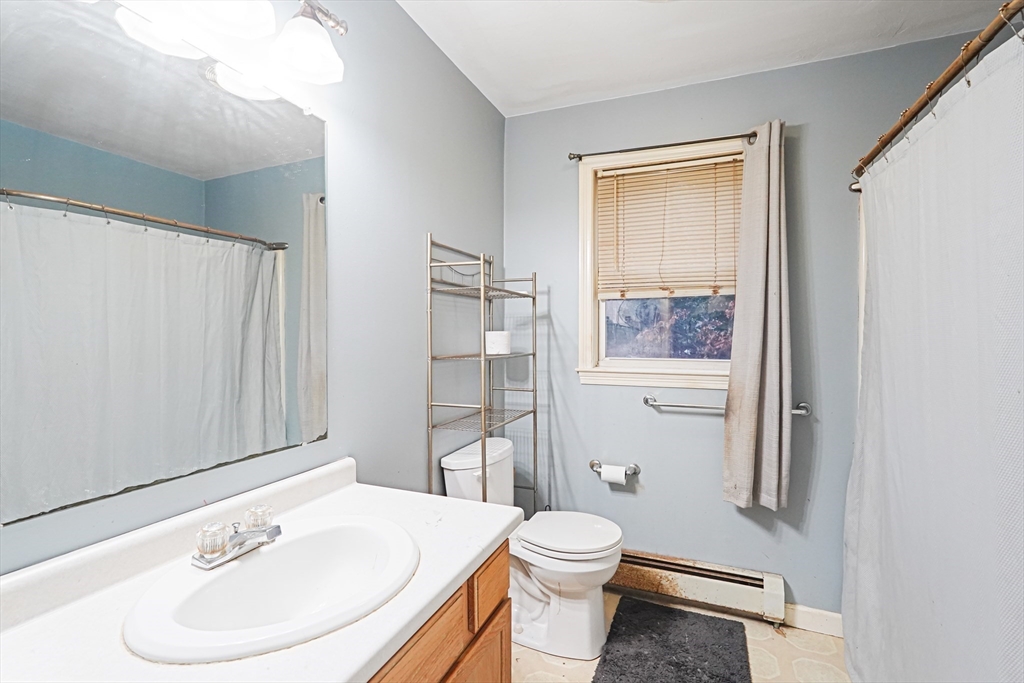 2 Warsaw Avenue, Unit 3 Dudley, MA 01571 - Photo 10 of 12 a bathroom with a toilet a sink and a mirror