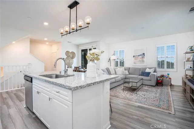 a kitchen with a stove a faucet and chandelier