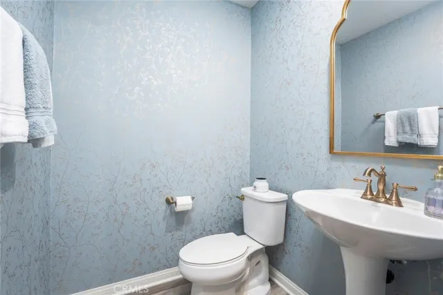 a bathroom with a sink a toilet and a mirror