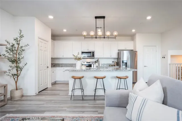 a large kitchen with white cabinets table and chairs