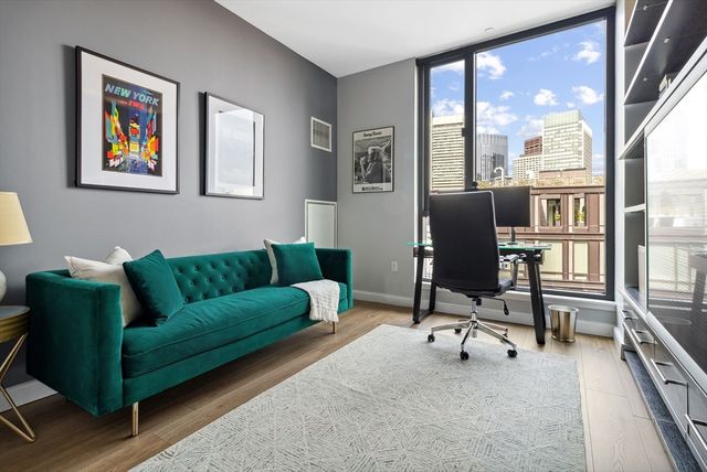 a living room with furniture and a floor to ceiling window