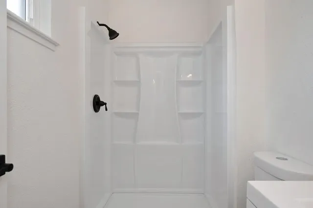 a view of a big room with wooden floor and windows