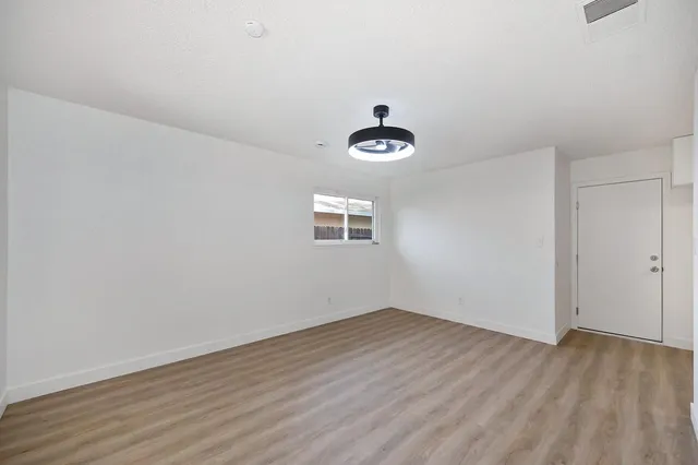 an empty room with windows and fireplace