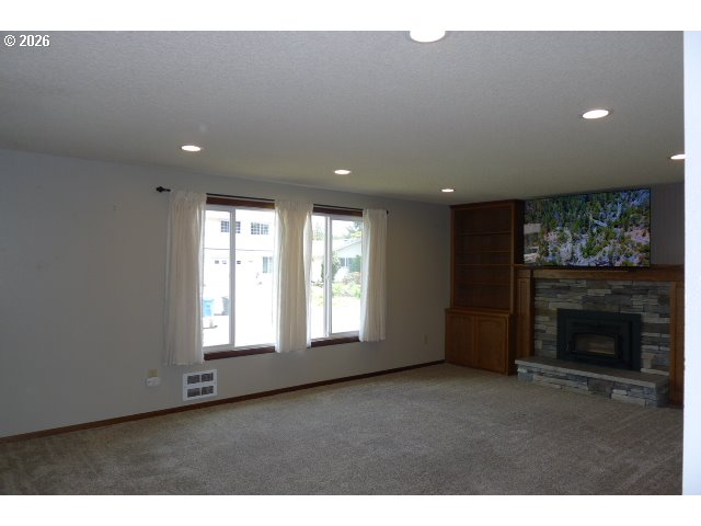 412 Camellia Court Reedsport, OR 97467 - Photo 37 of 48 a view of an empty room with a fireplace and a window