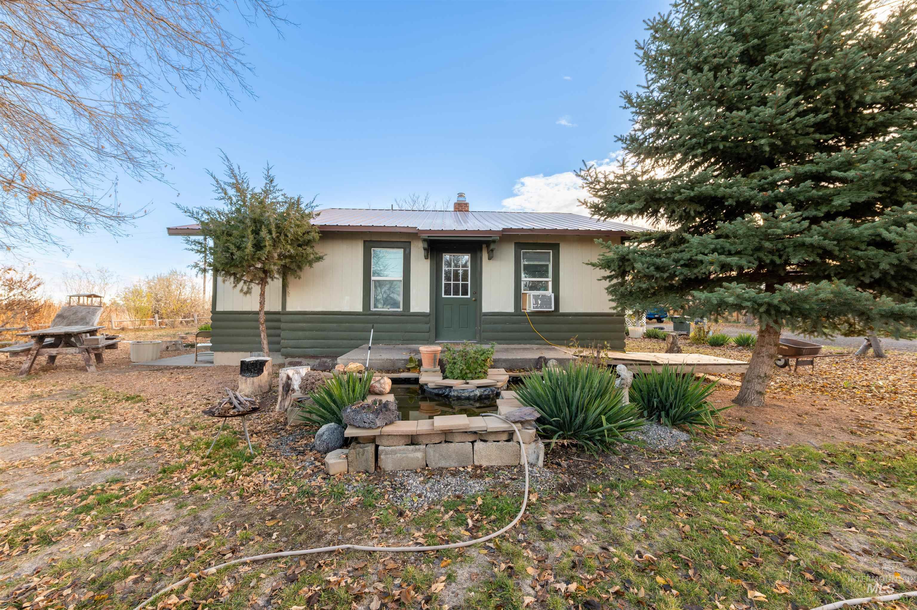 408 Clear Lakes Road Buhl, ID 83316 - Photo 12 of 16 Rear view of property featuring a metal roof, a chimney, and a patio