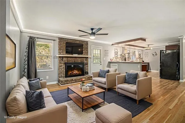 a living room with furniture kitchen view and a fireplace
