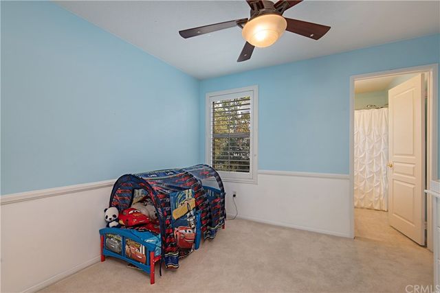 a bedroom with bed and a chandelier fan