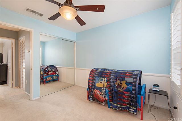 a bedroom with furniture and a chandelier fan