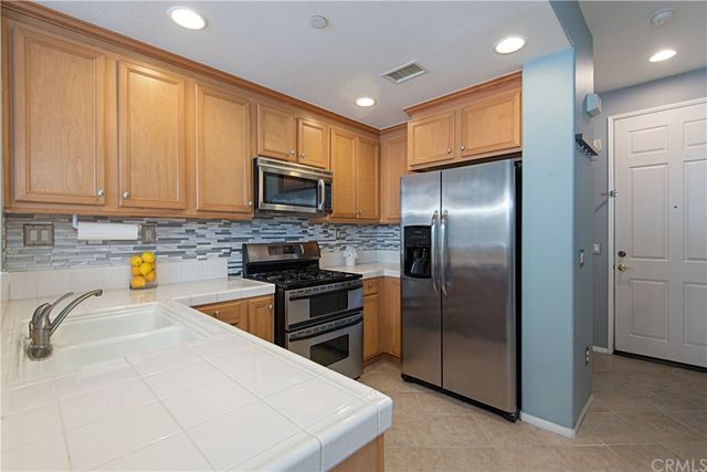 a kitchen with granite countertop a refrigerator and a sink