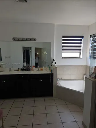 a bathroom with a bathtub sink vanity and mirror
