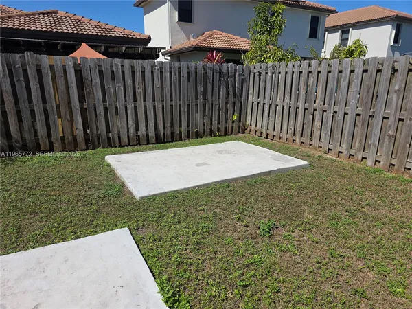 a view of a backyard with wooden fence