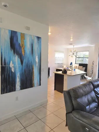 a living room with furniture and kitchen view