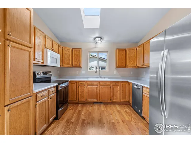 a kitchen with stainless steel appliances granite countertop a refrigerator a sink dishwasher a stove with wooden cabinets