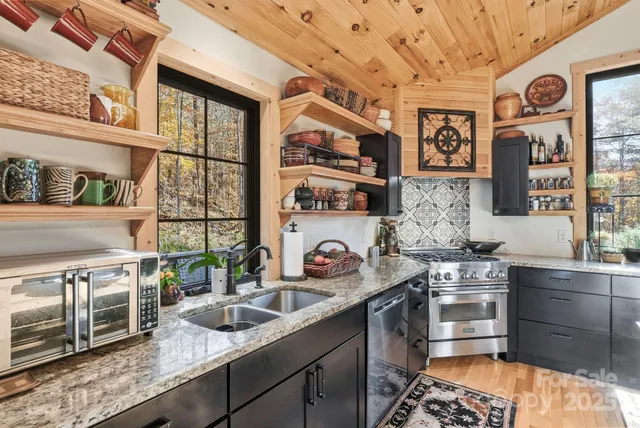 a kitchen with stainless steel appliances granite countertop a sink stove and cabinets