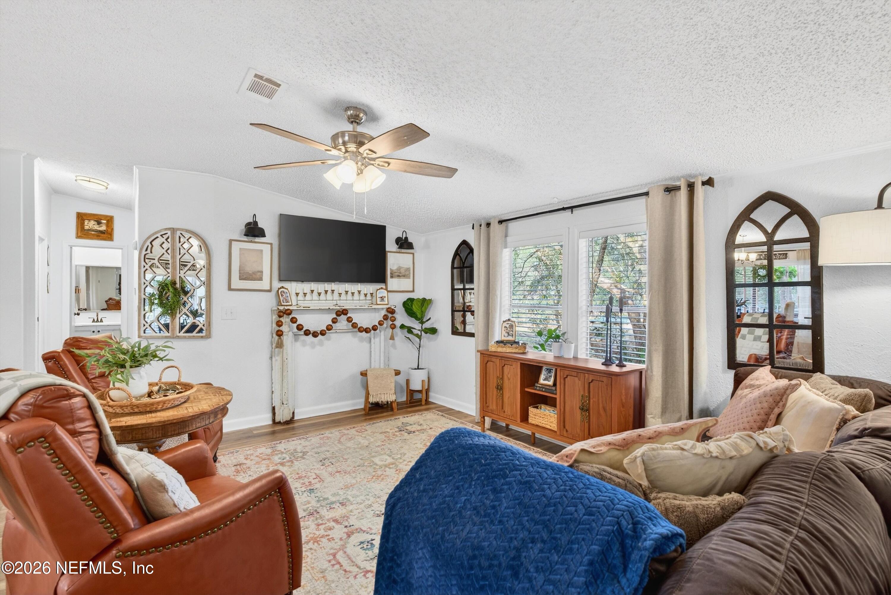 7655 Long Lake Road Keystone Heights, FL 32656 - Photo 11 of 58 a living room with furniture a flat screen tv and a large window