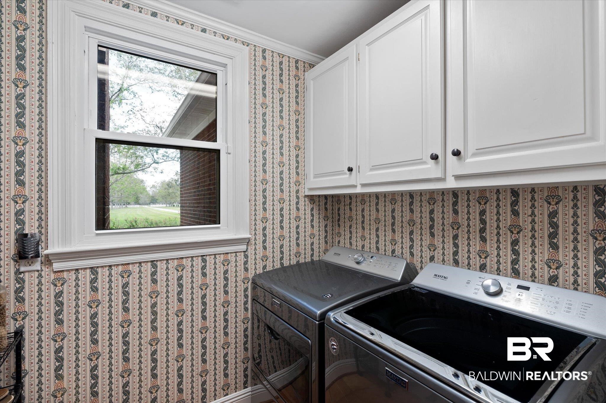5231 Dawes Road Grand Bay, AL 36541 - Photo 30 of 49 Laundry room featuring washing machine and dryer, ornamental molding, and cabinets