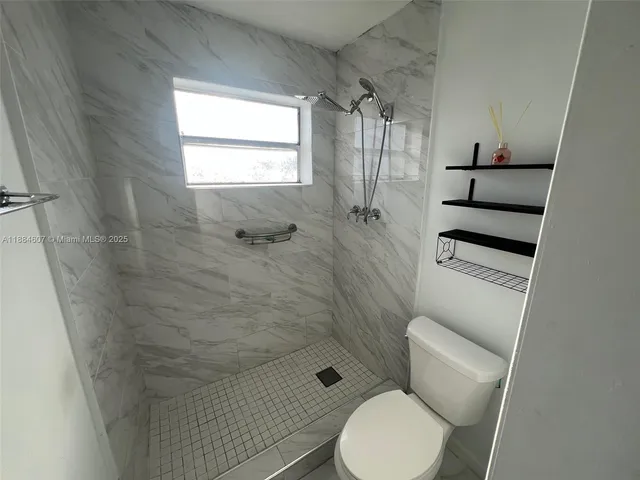 a bathroom with a toilet and a shower
