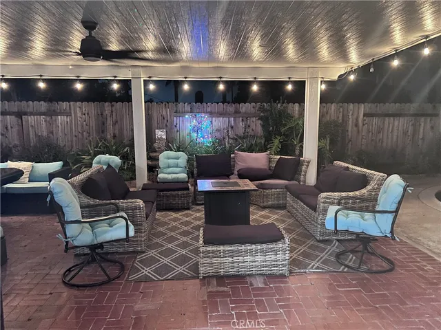 a living room with patio furniture and a ceiling fan
