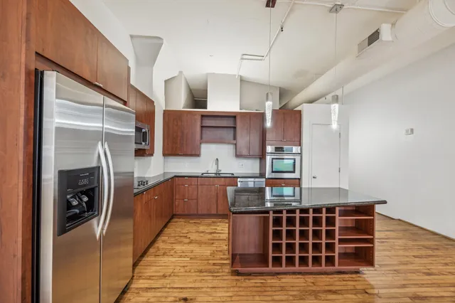 a kitchen with kitchen island granite countertop a stove and a refrigerator