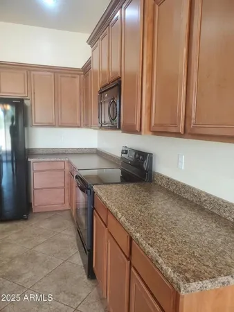 a kitchen with granite countertop a sink and a refrigerator