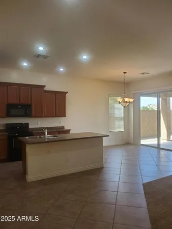 a large kitchen with stainless steel appliances a large counter top a stove and a refrigerator