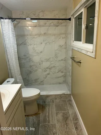 a bathroom with a toilet and a shower
