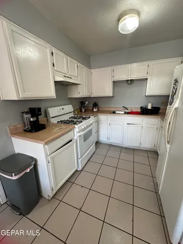a white stove top oven sitting inside of a kitchen