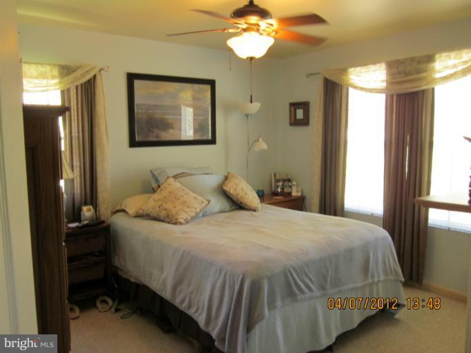 890 Maple Tree Road Severn, MD 21144 - Photo 8 of 15 a bedroom with a bed and a chandelier