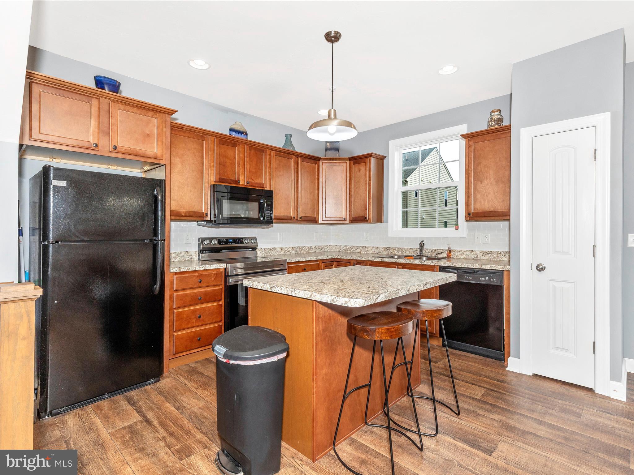 28 Brookside Avenue Hanover, PA 17331 - Photo 29 of 51 a kitchen with stainless steel appliances granite countertop a refrigerator a sink dishwasher a stove and a dining table with wooden floor