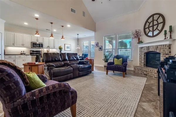 a living room with furniture a fireplace and a kitchen view
