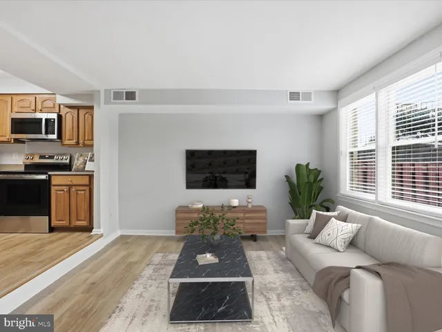 a living room with furniture a flat screen tv and a large window