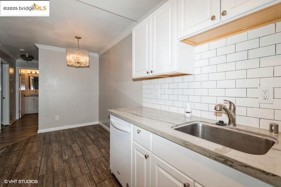 1505 Kirker Pass Road, Unit 170 Concord, CA 94521 - Photo 11 of 18 Kitchen with white cabinets, light stone counters, crown molding, a chandelier, and decorative backsplash