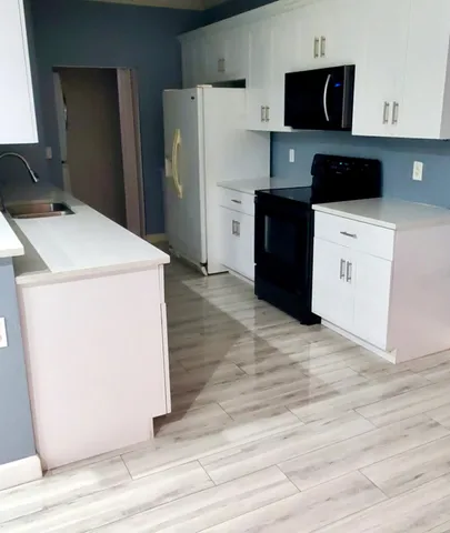 a kitchen with a refrigerator sink and cabinets