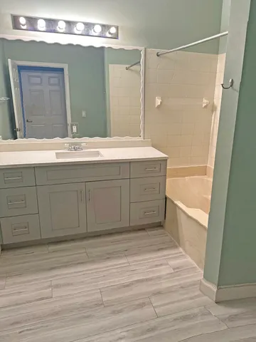 a bathroom with a tub sink and mirror