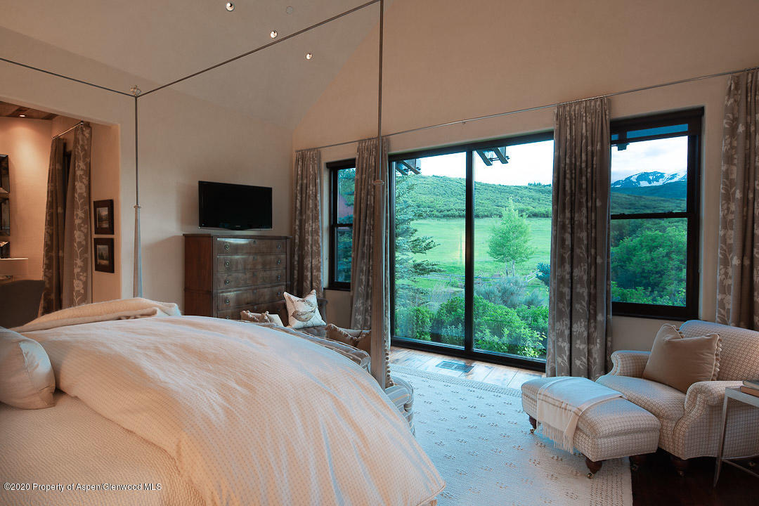 630 Spring Creek Road Basalt, CO 81621 - Photo 13 of 72 a bedroom with a bed and large windows