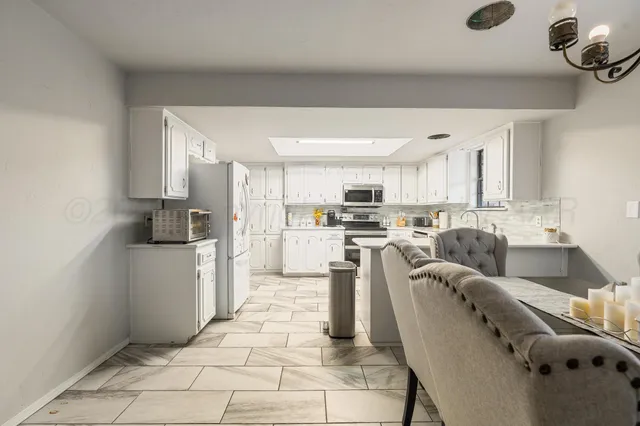 a kitchen with stainless steel appliances kitchen island granite countertop a sink and cabinets