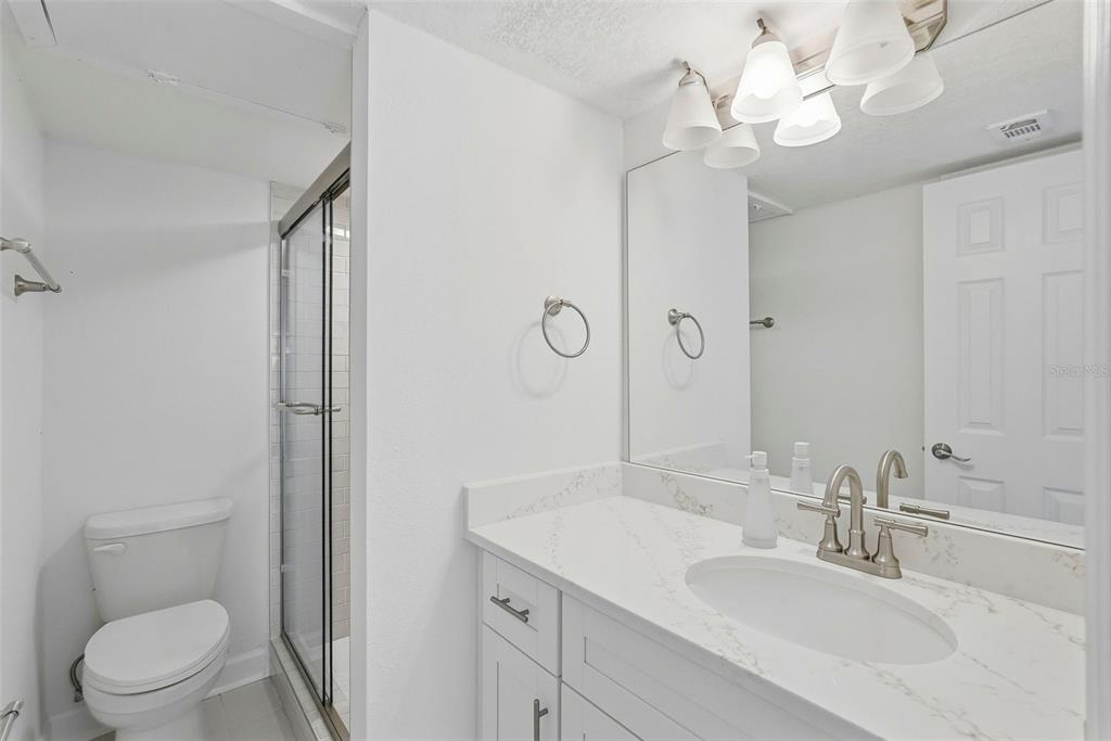 8921 Blind Pass Road, Unit 144 St. Pete Beach, FL 33706 - Photo 11 of 37 a bathroom with a sink a toilet and a mirror