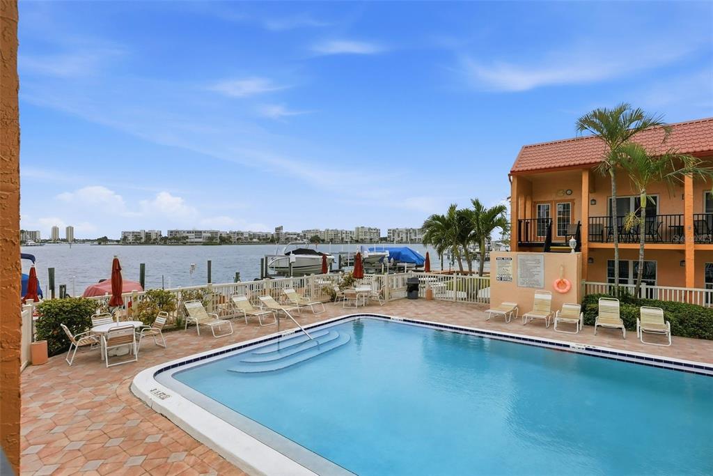8921 Blind Pass Road, Unit 144 St. Pete Beach, FL 33706 - Photo 16 of 37 a view of a swimming pool and lounge chair