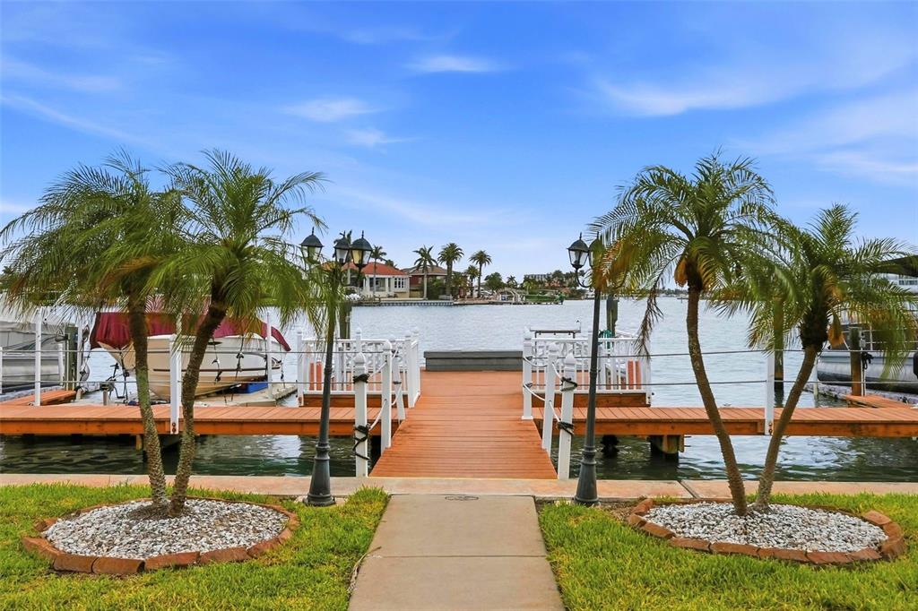 8921 Blind Pass Road, Unit 144 St. Pete Beach, FL 33706 - Photo 17 of 37 a view of a swimming pool with a table and chairs