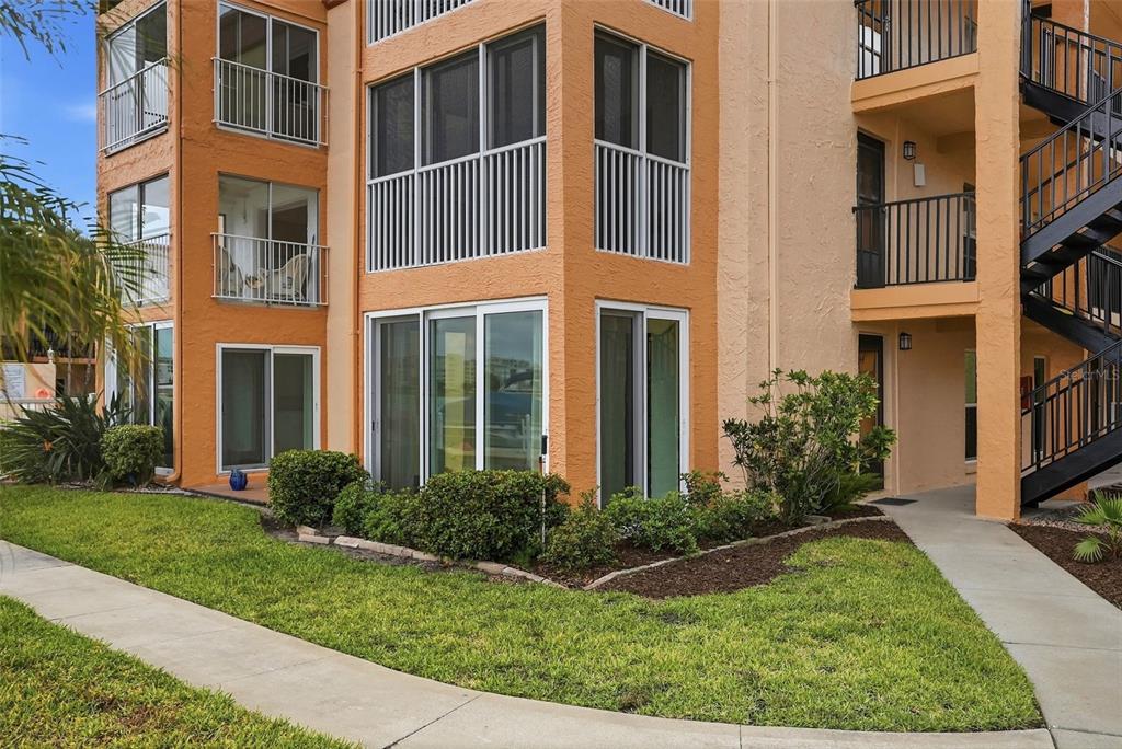 8921 Blind Pass Road, Unit 144 St. Pete Beach, FL 33706 - Photo 2 of 37 a view of a building with a yard