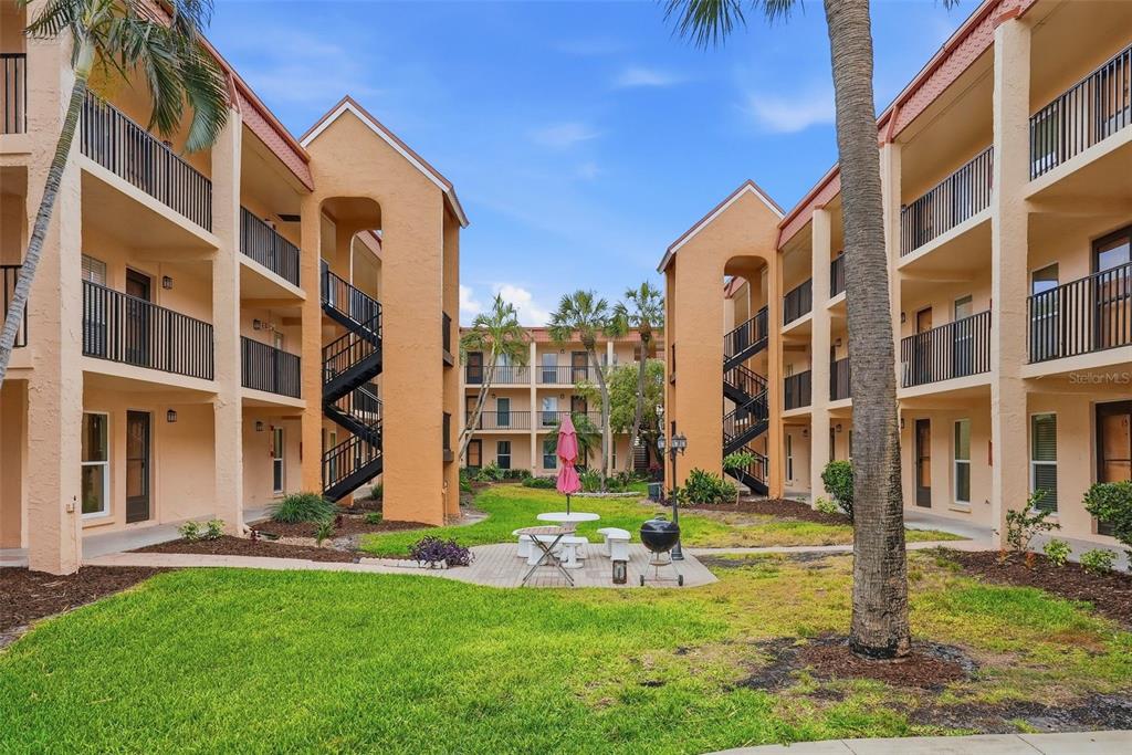 8921 Blind Pass Road, Unit 144 St. Pete Beach, FL 33706 - Photo 29 of 37 a view of building with yard