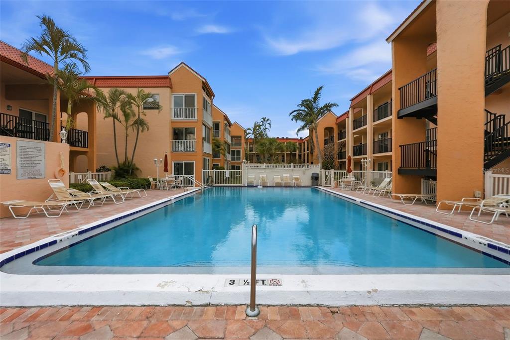 8921 Blind Pass Road, Unit 144 St. Pete Beach, FL 33706 - Photo 3 of 37 a view of a house with a swimming pool