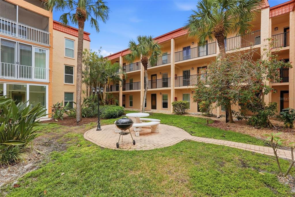8921 Blind Pass Road, Unit 144 St. Pete Beach, FL 33706 - Photo 31 of 37 a house that has a garden in front of it